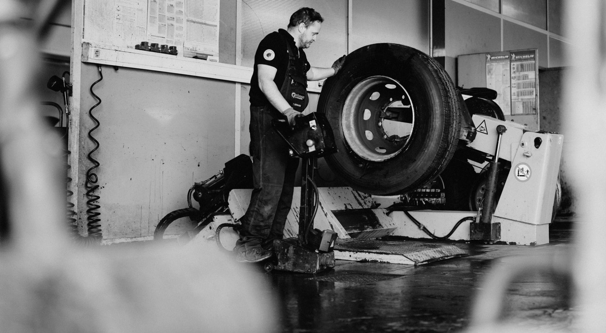 Mitarbeiter arbeitet an einem Lkw-Reifen – Service für Nutzfahrzeuge und Busse.