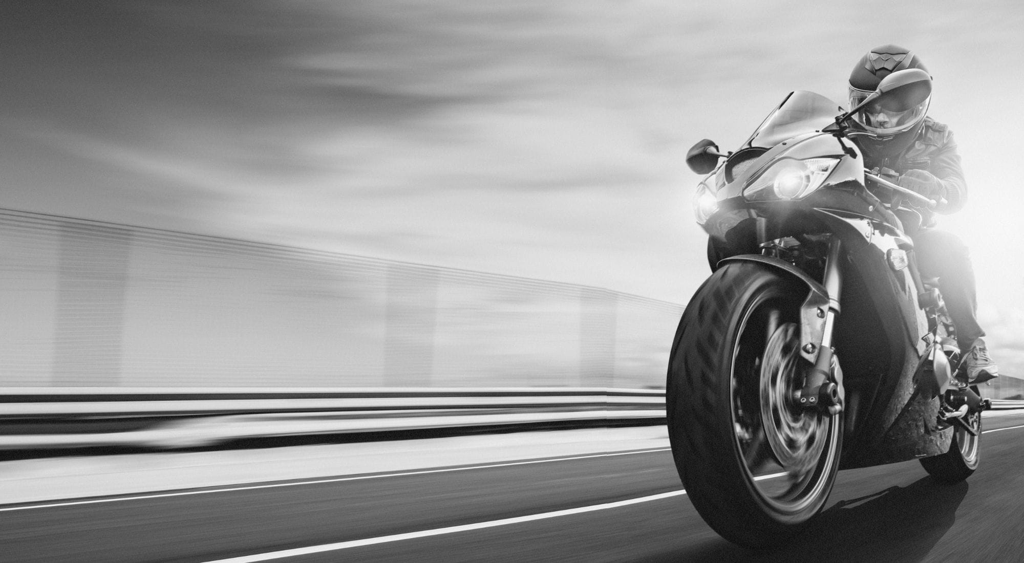 Motorrad steht am Straßenrand, Fokus auf Hinterreifen.