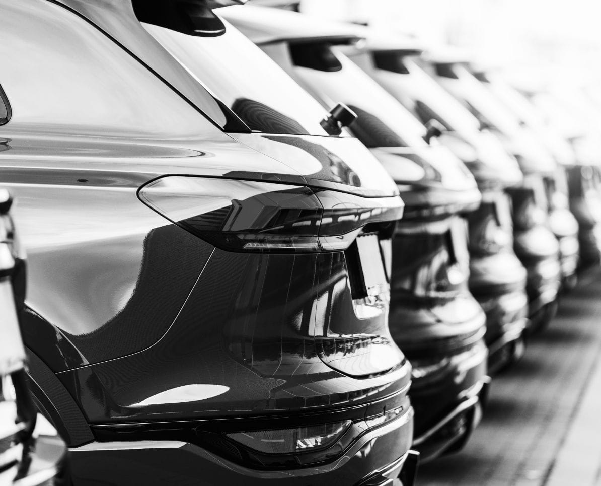 Fuhrpark mit mehreren Fahrzeugen, geordnet auf einem Parkplatz.