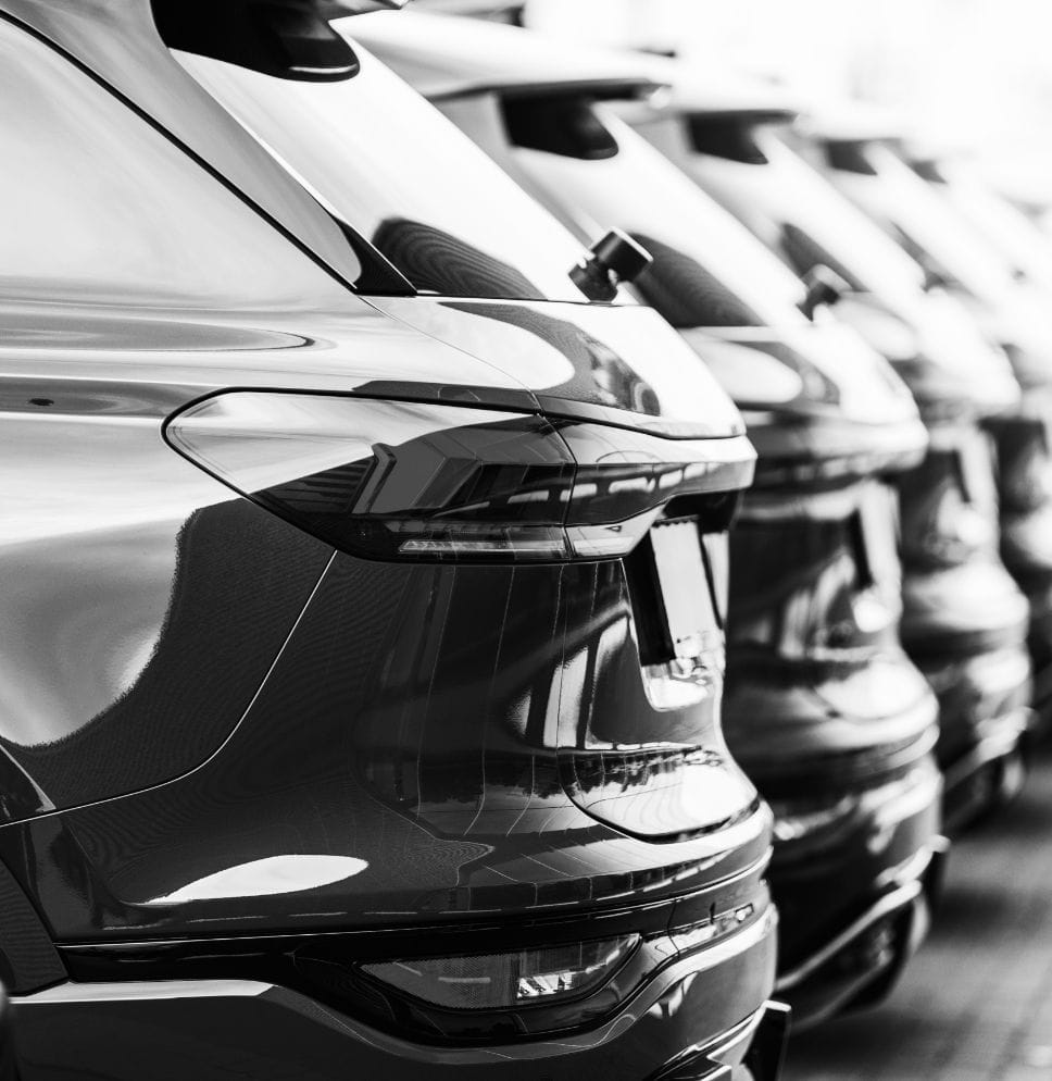 Mehrere Fahrzeuge in einer Reihe geparkt auf einem Betriebsgelände.