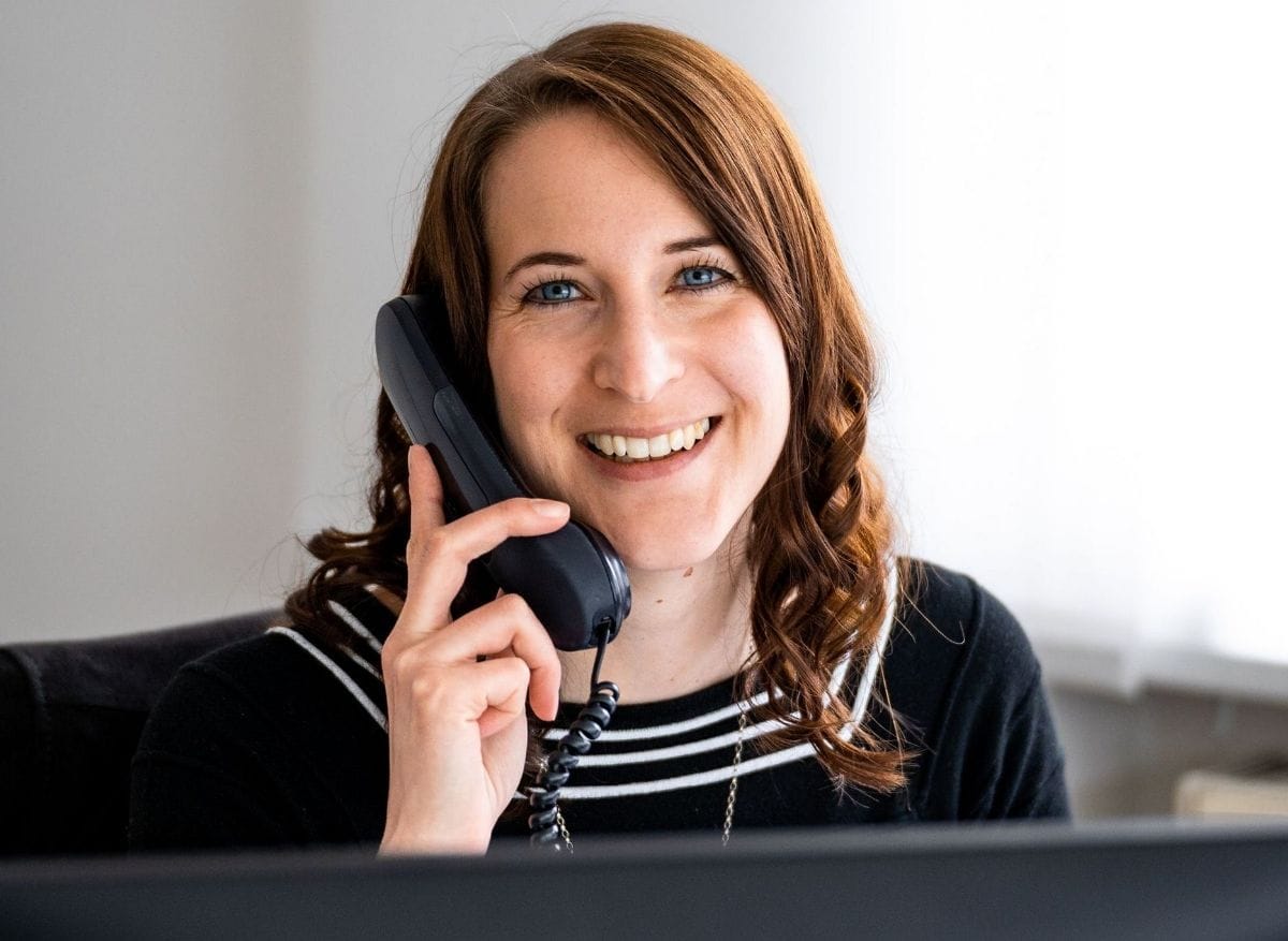 Mitarbeiterin am Telefon, freundlich und professionell – Symbol für Kundenservice.