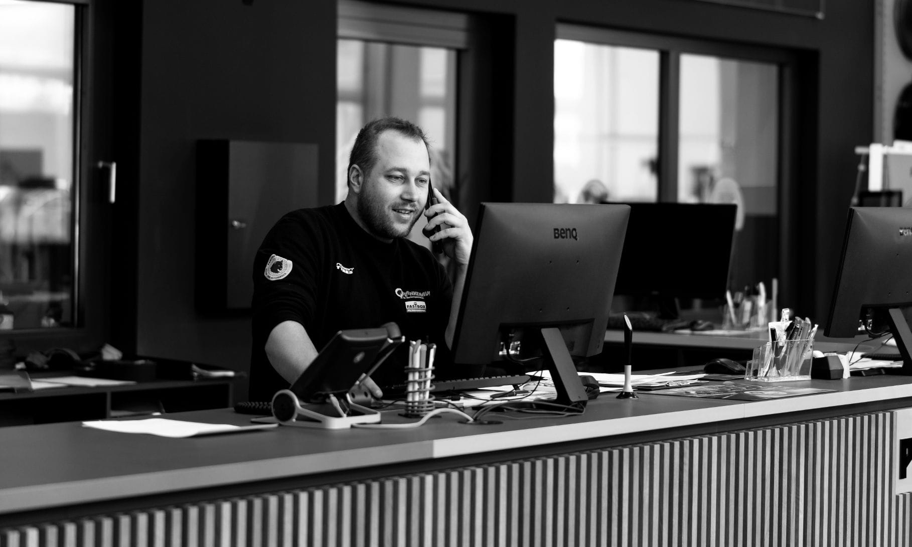 Ein Mitarbeiter sitzt hinter der Rezeption im Plankenauer-Kundenzentrum.