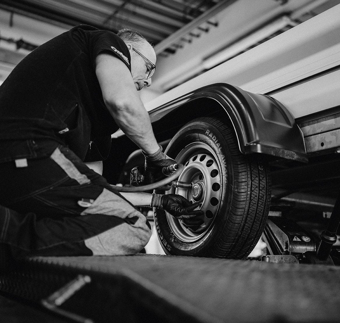 Ein Monteur beim Reifenservice für Nutzfahrzeuge in einer professionellen Werkstatt.